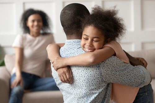 A child hugging their parents with joint custody in Ohio
